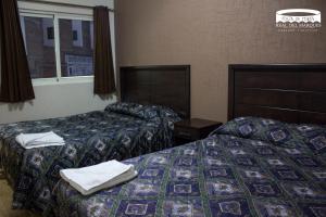 - 2 lits dans une chambre d'hôtel avec des serviettes dans l'établissement Real Plaza de Toros, à San Juan de los Lagos