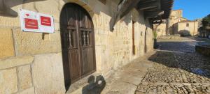 a building with a door and a sign on it at Casa del Lavadero in Santillana del Mar