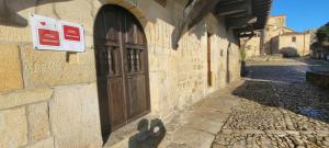 a building with a door and a sign on it at Casa del Lavadero in Santillana del Mar +17 photos