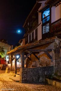 a building with awning on a street at night at Casa del Lavadero in Santillana del Mar