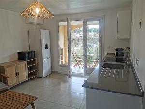 una cocina con encimera y refrigerador en T2 au cœur du Golfe de Saint Tropez, en Cogolin