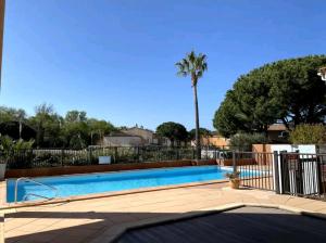 una piscina con valla y palmera en T2 au cœur du Golfe de Saint Tropez, en Cogolin