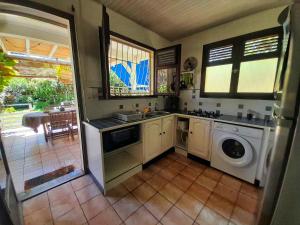 een keuken met een spoelbak en een wasmachine bij Appartement Papay dans Villa Fleurs des Iles in Le Vauclin