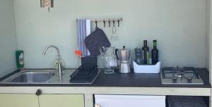 a kitchen counter top with a sink and a sink at Três figos Caravan in São Luis
