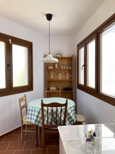 a dining room with a table and chairs and windows at L57 - Habitaciones en Órgiva in Órgiva