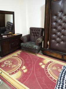 a living room with a chair and a mirror at شقة فاخرة مع مطل in Amman