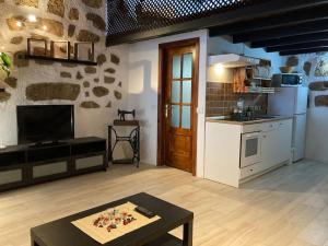 a kitchen and a living room with a table in a room at Casa Rural Tamaide in San Miguel de Abona