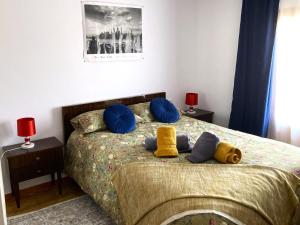 een slaapkamer met een bed met blauwe en gele kussens bij L57 - Habitaciones en Órgiva in Órgiva