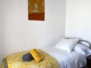 - une chambre avec un lit et une serviette jaune dans l'établissement L57 - Habitaciones en Órgiva, à Órgiva