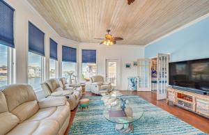 a living room with a couch and a tv at Hernando Beach Home on Dolphin Cove Dock and Kayaks in Hernando Beach