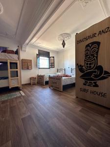 een kamer met een stapelbed en een bord met de tekst "Sing House" bij Dinosaur Anza Surf House in Agadir