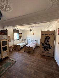 アガディールにあるDinosaur Anza Surf Houseのベッド3台と箱が備わる部屋