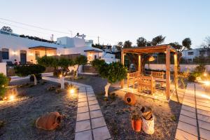 einen Hinterhof mit einem Pavillon, Bäumen und Lichtern in der Unterkunft Kalathos Square luxury suites in Kalathos