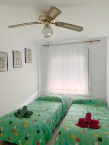 1 dormitorio con 2 camas y ventilador de techo en Room in Apartment - Apartment for 4-5 people 70 m from the beach, en Miami Platja