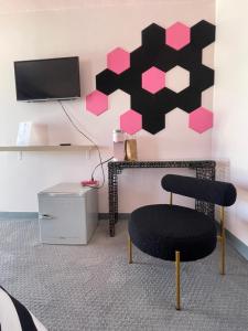 una silla en una habitación con una pared de color rosa en Rainbow Motel, en Greeley