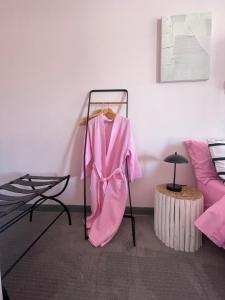 格里利的住宿－Rainbow Motel，房间里的架子上有一个粉红色的长袍