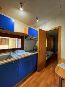 a kitchen with blue cabinets and a sink at CAMPING AMALASUNTA in Montefiascone