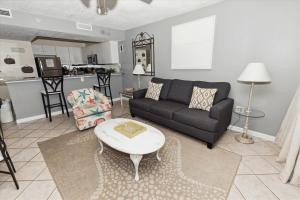 uma sala de estar com um sofá e uma mesa em Pelican Beach 1811 Destin Condo em Destin