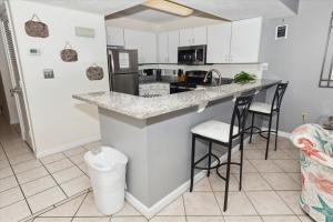 a kitchen with a counter and two bar stools at Pelican Beach 1811 Destin Condo in Destin