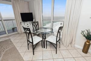 a glass table and chairs in a room with a window at Pelican Beach 1811 Destin Condo in Destin
