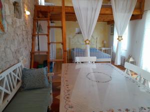 1 dormitorio con 1 cama blanca grande y mesa en Moja posebna kuća na osami kraj mora, en Vis