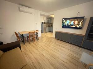 a living room with a table and a television on a wall at Vila Thera in Mangalia