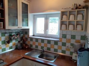 cocina con fregadero y ventana en Moja posebna kuća na osami kraj mora, en Vis