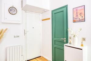 eine grüne Tür in einem Zimmer mit einer weißen Wand in der Unterkunft Le Central Green Studio Parisien Cosy Proche Métro in Clichy