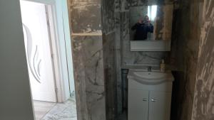 a person taking a picture of a bathroom with a mirror at Twins Residence 2 APART HOTEL Ap 6 2 rooms in Chiajna +13 photos