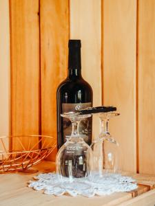 a bottle of wine and two glasses on a table at Sítio caminho das nascentes in Urubici