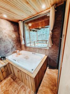 a bathroom with a sink and a window at Sítio caminho das nascentes in Urubici