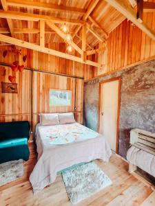 a bedroom with a bed in a room with wooden walls at Sítio caminho das nascentes in Urubici