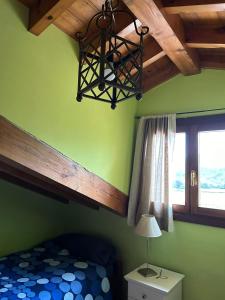 um quarto com uma cama, um lustre e uma janela em La Casina de Niembro em Niembro
