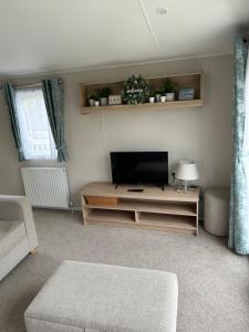 a living room with a flat screen tv on a table at Secluded spot on Southview 8 berth in Lincolnshire