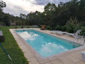 a swimming pool with chairs and a grill in a yard at Casa Campo do Telhado in Caldelas