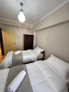 ein Schlafzimmer mit 2 Betten und einer beleuchteten Lampe in der Unterkunft Andi's Apartment 2 in Gjirokastër