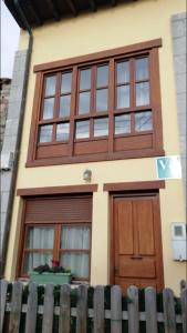 uma casa com janelas e uma porta de madeira em La Casina de Niembro em Niembro