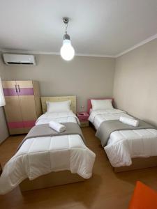 Zimmer mit 3 Betten in einem Zimmer in der Unterkunft Andi's Apartment 2 in Gjirokastër