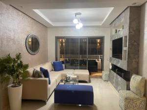 uma sala de estar com um sofá e uma televisão em Très bel appartement neuf à Mansbay Manssouria em Mohammedia
