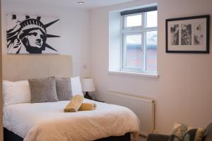 a bedroom with a bed and a window at Birmingham City Apartments - spacious with free secure parking in Birmingham