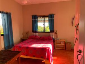 um quarto com uma cama vermelha e uma janela em Palma Real 1 em Madama