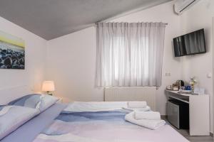 a bedroom with a bed with towels on it at Rooms Anna in Trogir