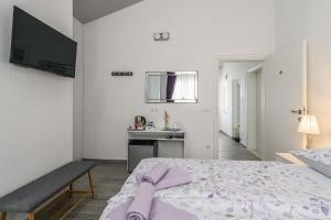 a white bedroom with a bed and a sink at Rooms Anna in Trogir