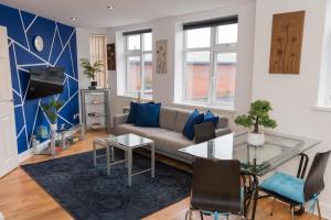 ein Wohnzimmer mit einem Sofa und einem Glastisch in der Unterkunft Birmingham City Apartments - spacious with free secure parking in Birmingham