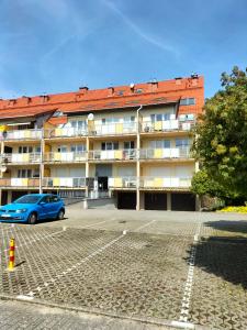 a blue car parked in front of a building at Apartament Klaudia in Stegna