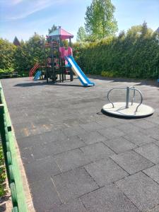 a playground with a slide and a play equipment at Apartament Klaudia in Stegna