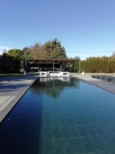 uma piscina com água azul em frente a um edifício em Agréable studio 3 au calme absolu a Cabries 13480 em Cabriès