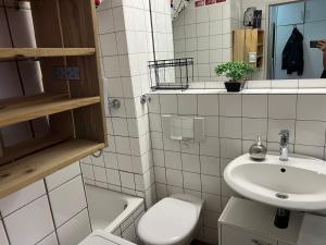 a white bathroom with a sink and a toilet at Recharge in the wonderful heart of Cologne! in Cologne