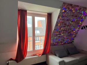 una sala de estar con una ventana con cortinas rojas en Recharge in the wonderful heart of Cologne!, en Colonia