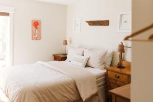 a white bedroom with a white bed and a window at Maison Marigold ST-2019-0060-R5 in Bloomfield